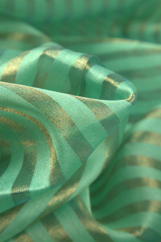 Close-up of mint green Chanderi saree fabric with gold zari stripes and soft texture